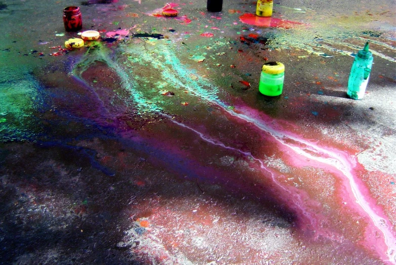 an artistic pograph of paints, tubes, and sprays on the ground