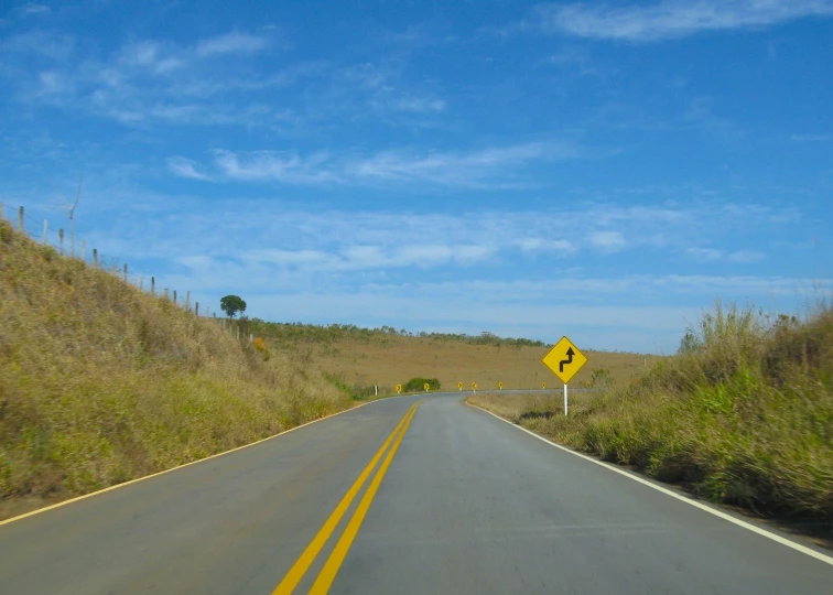 an empty road on the side of the mountain