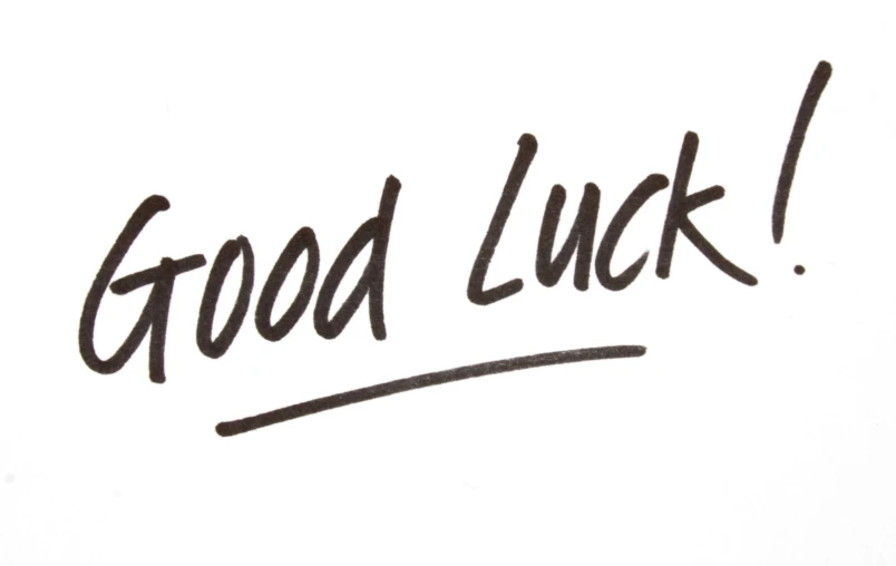 a black ink writing inscription good luck over a white background