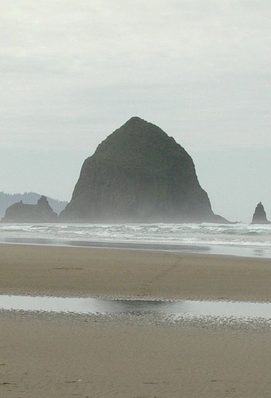 a man walking on top of a sandy beach