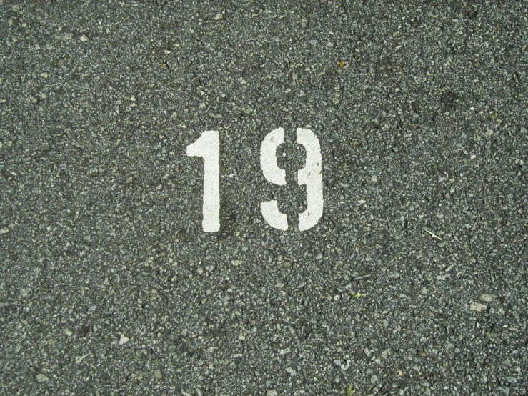 a close up of the number nineteen painted on a street