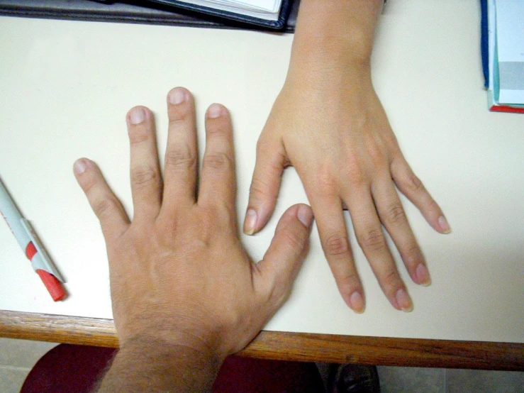 a person's hand on top of a table