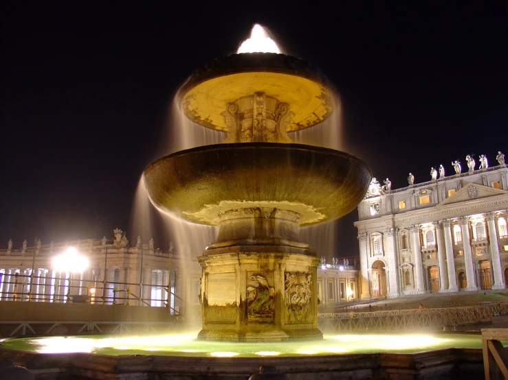 a large yellow water fountain next to a building