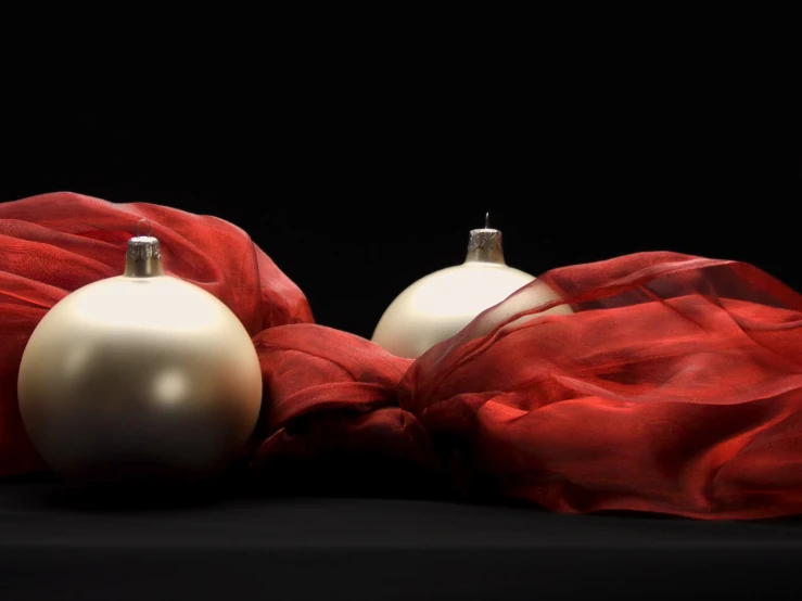 two christmas balls wrapped in red cloth