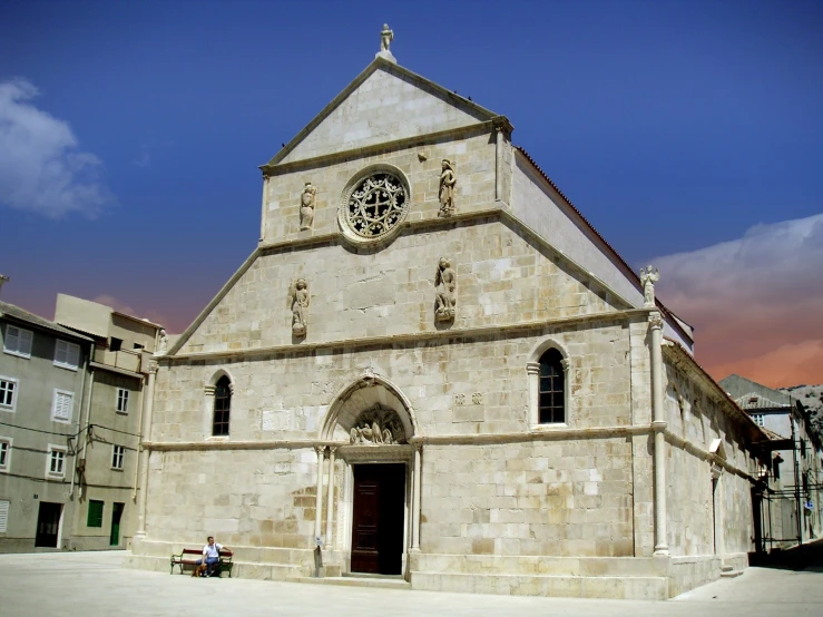 two people sit outside an old church