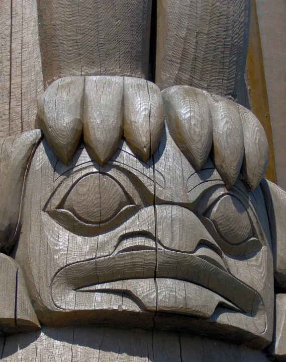 a carved wooden object depicting an eagle's face