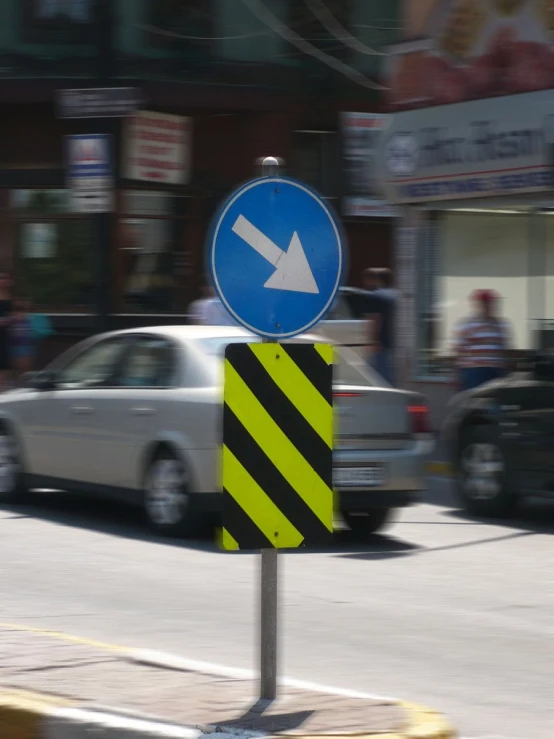 an arrow sign on the corner of a street