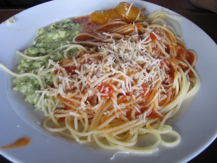 a close up of spaghetti on a plate with sauce