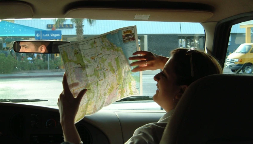 two people in a vehicle are observing a map