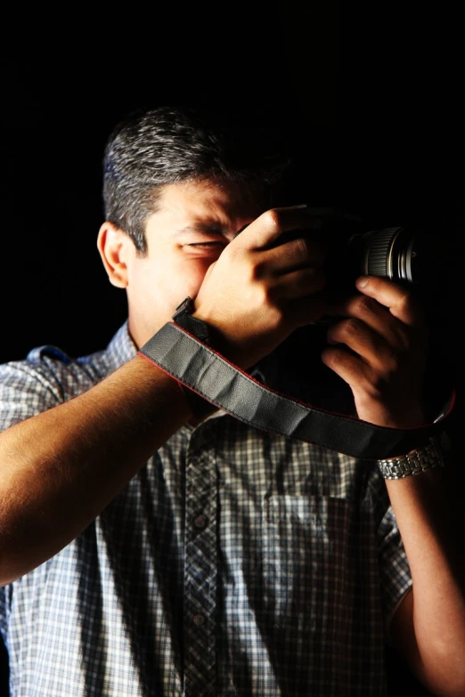 a man standing holding up a camera in front of his face