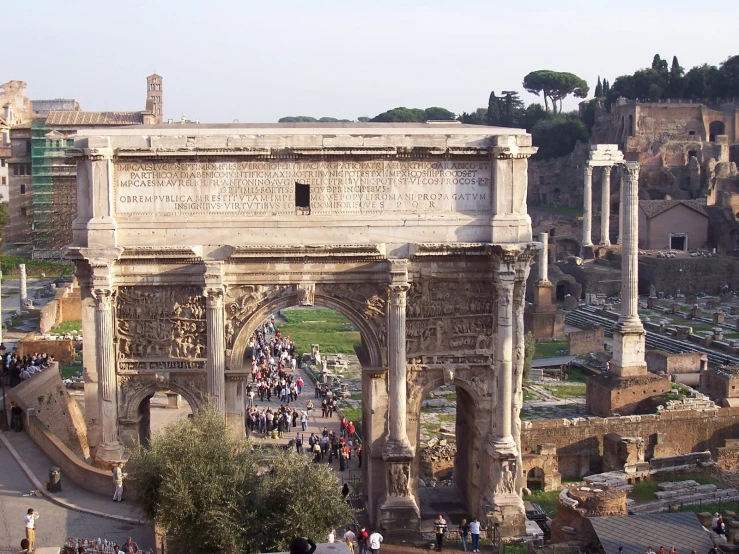 a large crowd gathered around the arch of triumph in roman ruins