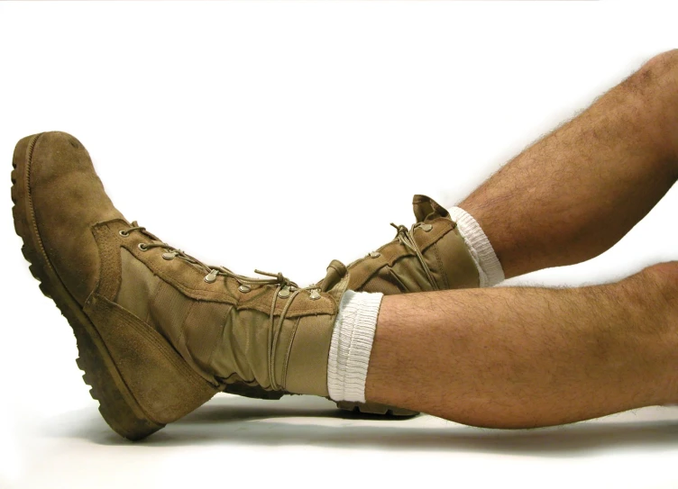 an image of a man laying down wearing military boots