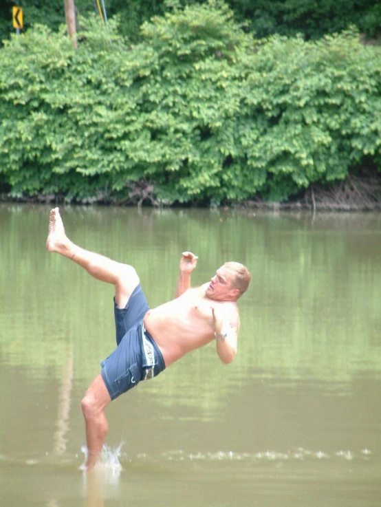 a man dives in the water from a dock