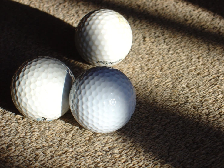 three white balls laying on a carpet next to each other