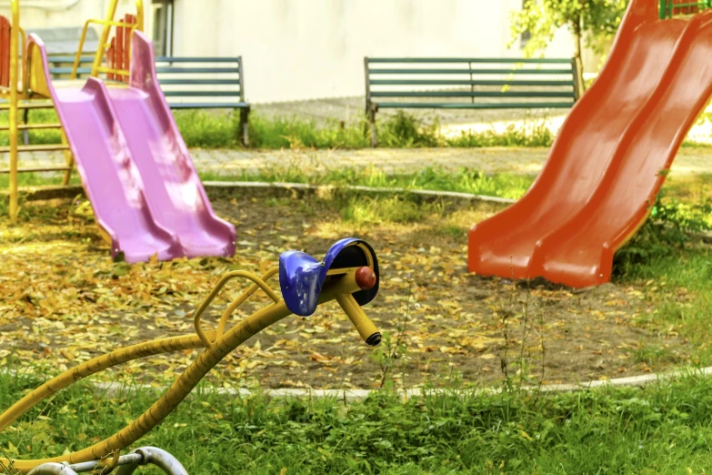 a playground area with a swing, swings and slides