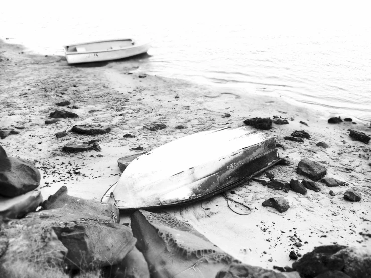 a broken surfboard and some rocks on the beach