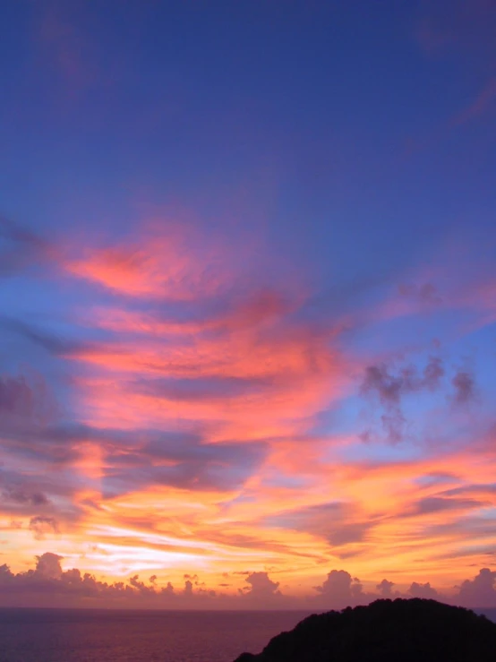 bright sunset with clouds over the sea and hills