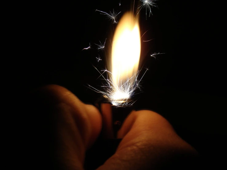 a person lighting a lighter in the dark