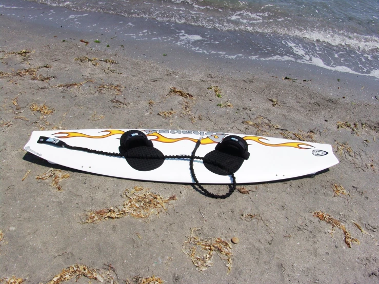 there is a surf board and goggles on the beach