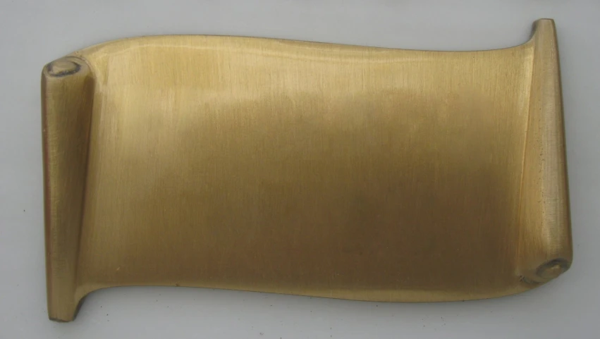 an antique gold metal plate on a white table