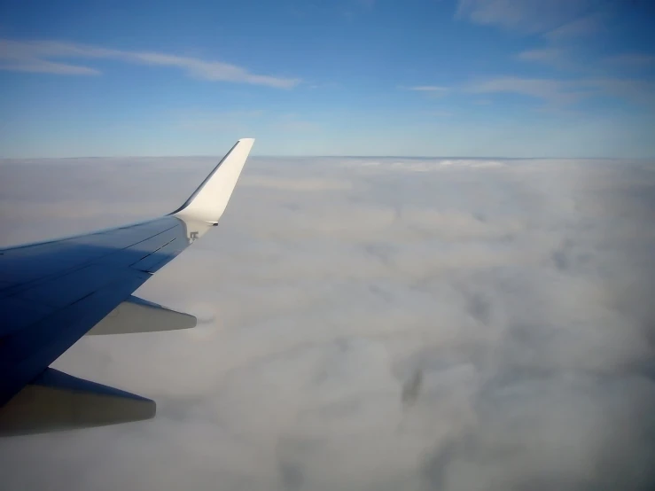 an airplane is flying over some clouds