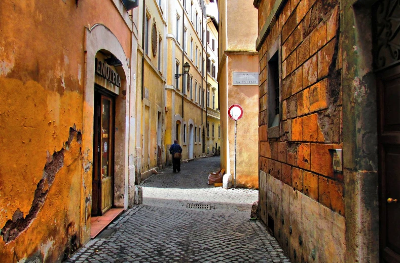 a cobblestone road going through the center of buildings