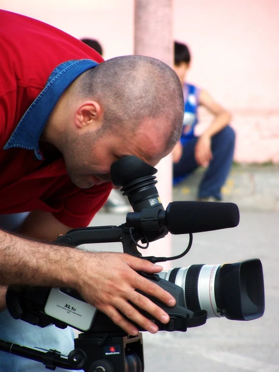 a man holding a camera near a giant lens