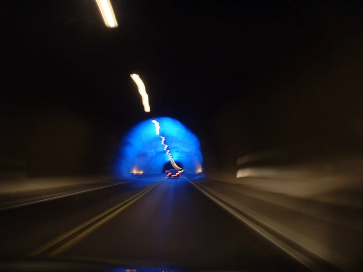 blurry image of a blue tunnel with cars