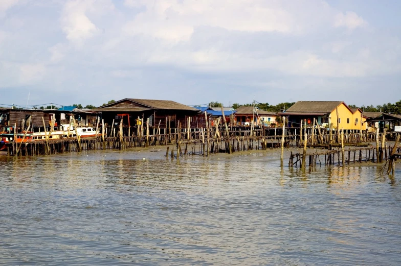 an old dock and the water with houses next to it