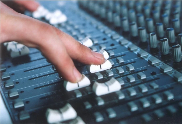 a hand on top of a sound mixer