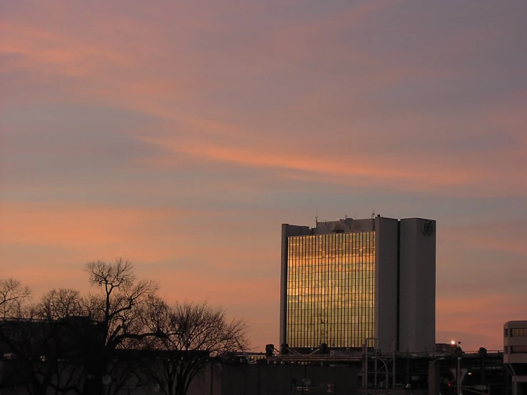 a sunset scene in a city with some tall buildings