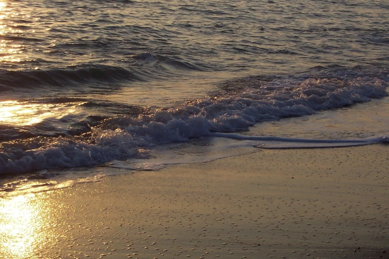 some small waves on the shore at sunrise