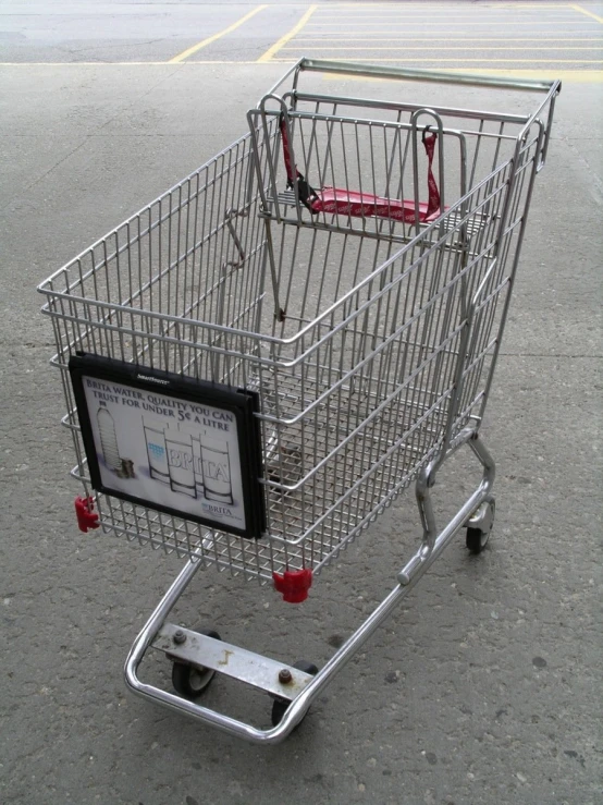 a shopping cart with a screen and red handles on it