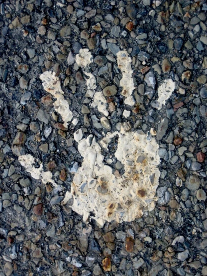 a rock road has a white hand painted on it