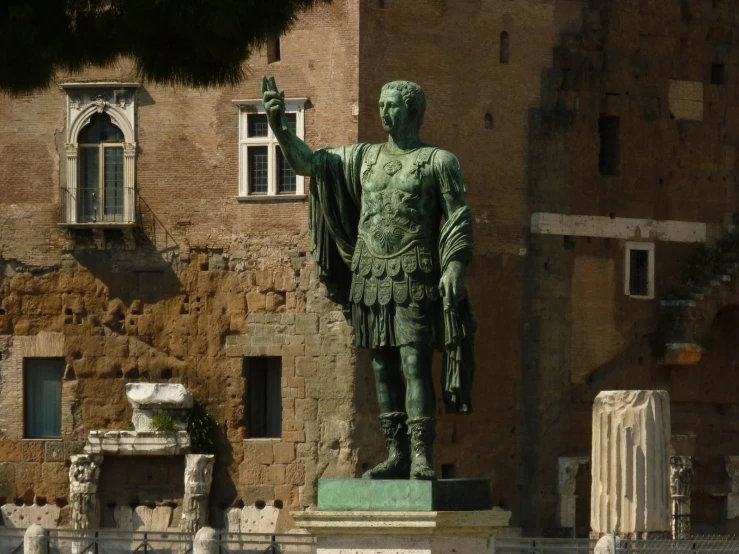 a statue stands on the ground next to a building