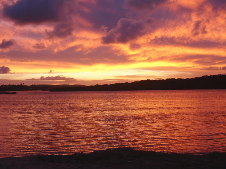 beautiful sunset over the ocean and boat at waters edge