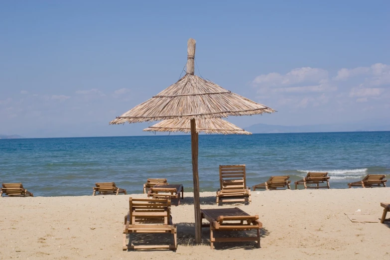 a bunch of lawn chairs sitting in front of a umbrella