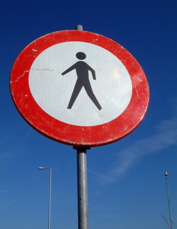 a street sign depicting a man walking the street