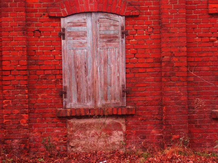 the wooden shutters are closed behind the red brick building