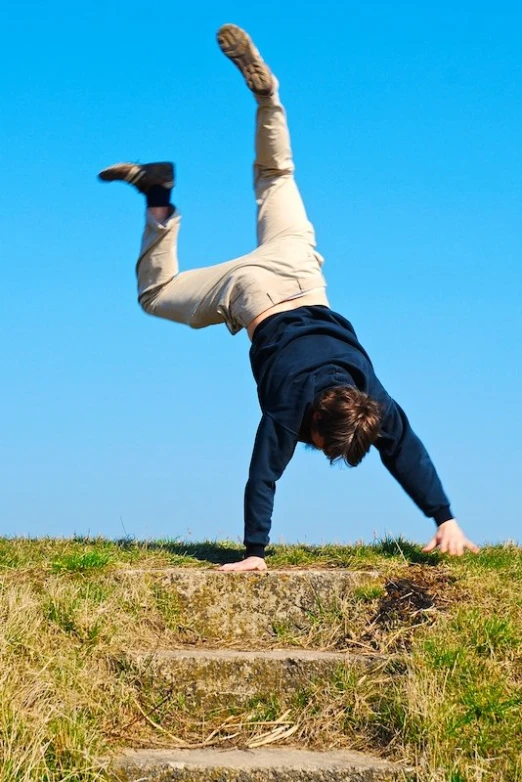 a young man on top of some stairs doing a handstand