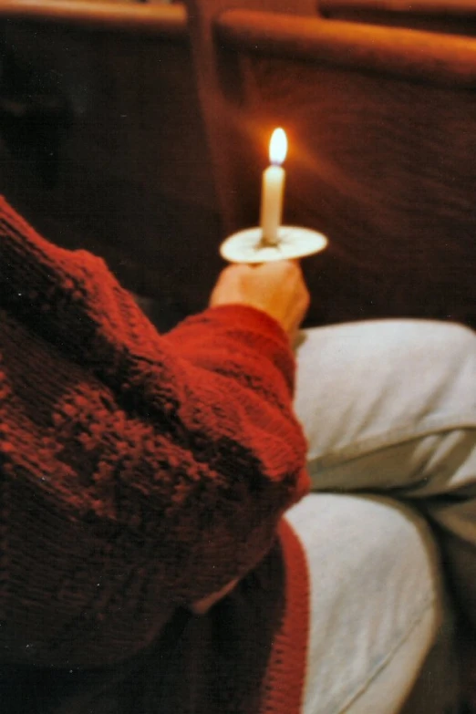 someone holding a lit candle in their hand