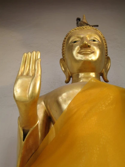 there is a golden buddha statue in front of a wall