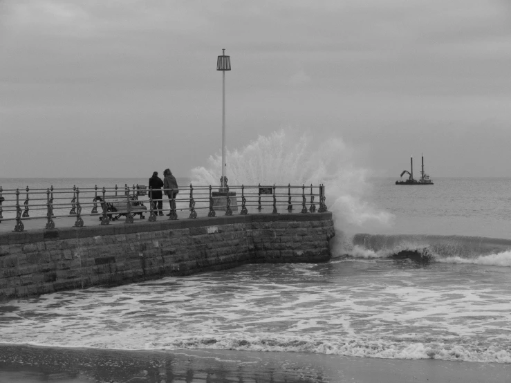 a couple of people that are standing on a pier near water