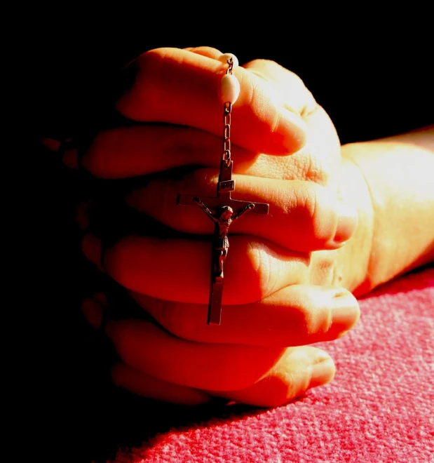 a small cross being held in someone's hands