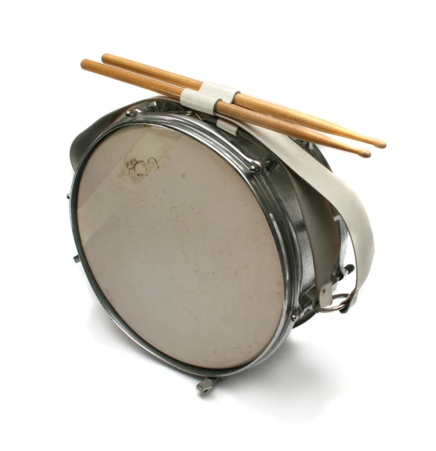 a drum and drumsticks on top of a small metal object