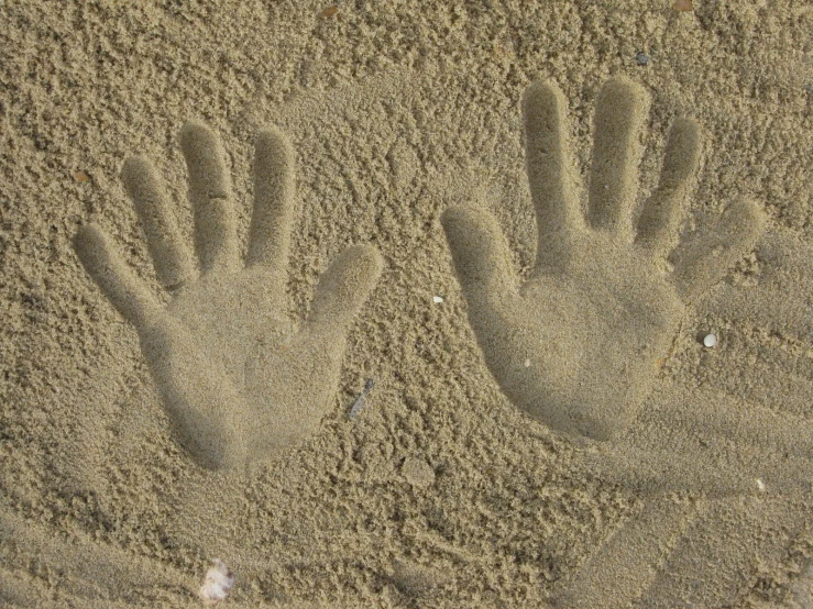 a pair of hand prints in the sand