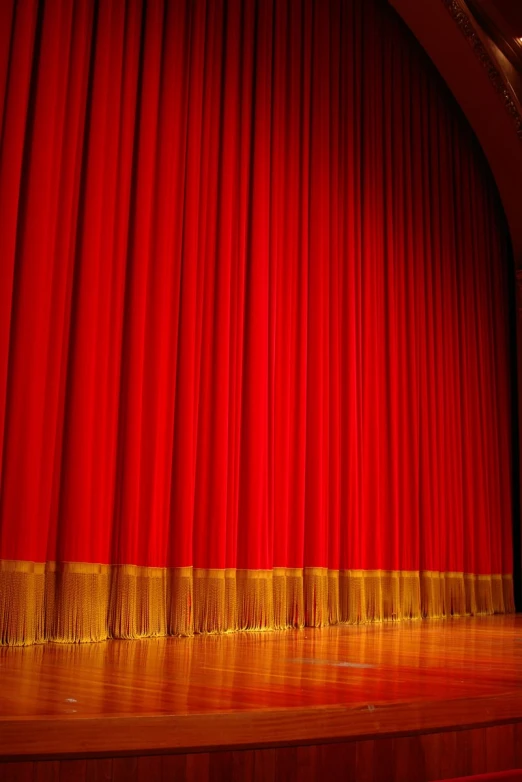 a large red theater stage curtain with a gold border