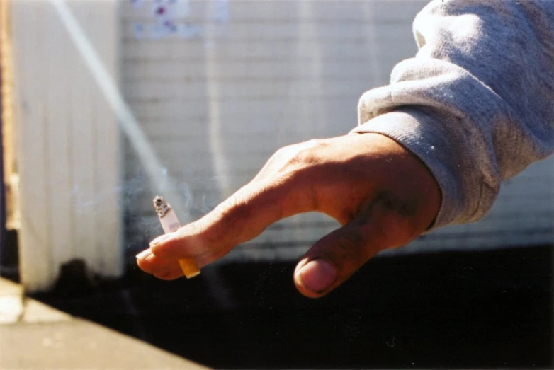 a person is smoking soing on the side of the street