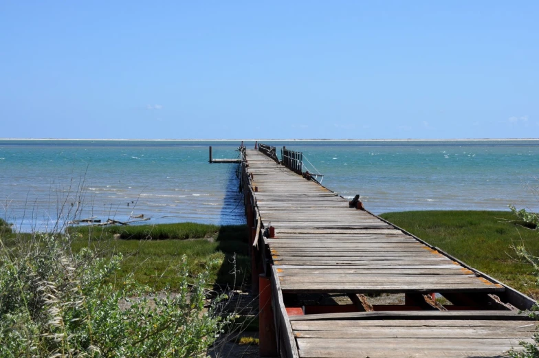 a long dock is open and there are water in the background