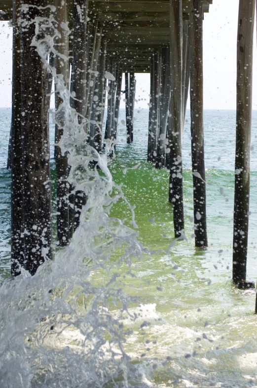 water splashing under a pier, as seen from under